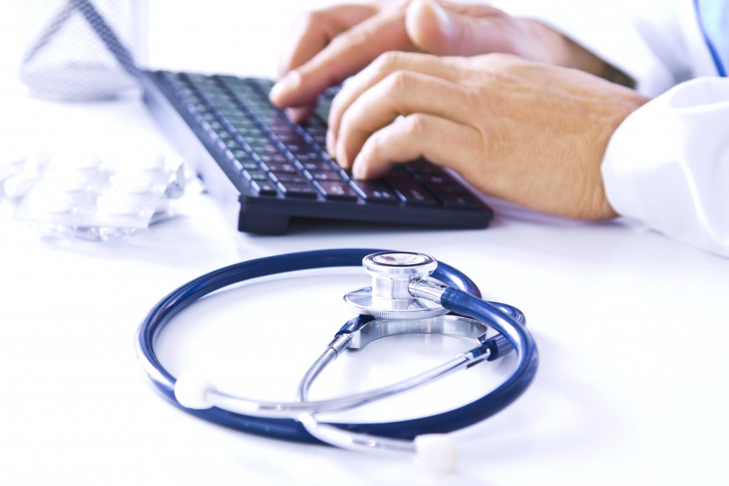 medical consultation with stethoscope and computer